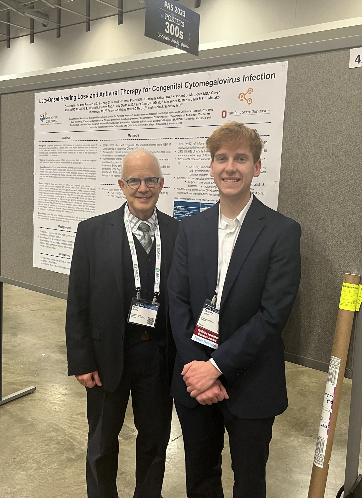 Zach Lewald and Pablo Sánchez standing in front of a congenital CMV poster at PAS 2023